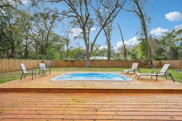 view of swimming pool with a lawn, a wooden deck, and a fenced backyard