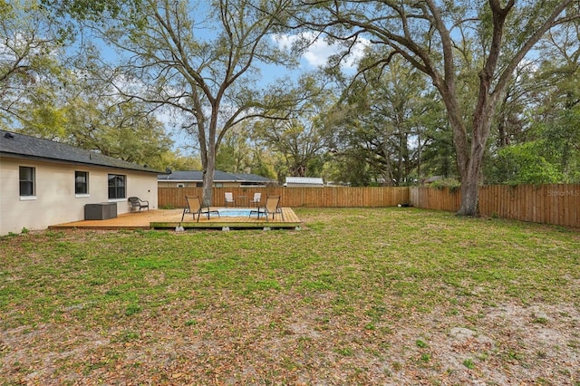 view of yard with a deck, central air condition unit, and a fenced backyard