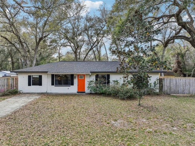 ranch-style home featuring stucco siding and fence