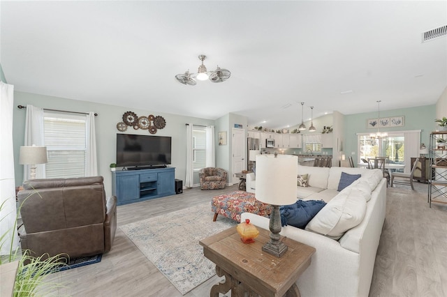 3786 Stephanie Way, The Villages, FL 32163 - living room with a notable chandelier, light wood-type flooring, visible vents, and vaulted ceiling
