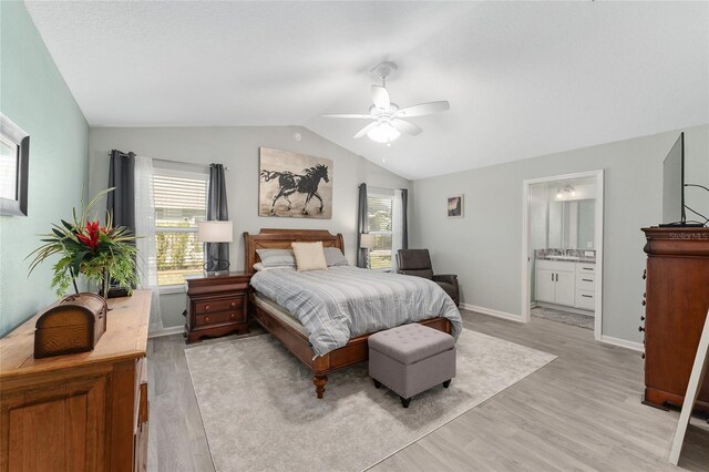3786 Stephanie Way, The Villages, FL 32163 - bedroom featuring vaulted ceiling, light wood-style flooring, baseboards, and ensuite bathroom