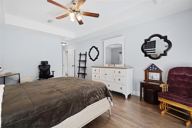 8880 SE 161st St, Summerfield, FL 34491 - bedroom featuring visible vents, baseboards, ceiling fan, wood finished floors, and a raised ceiling