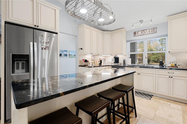 8880 SE 161st St, Summerfield, FL 34491 - kitchen featuring backsplash, dark stone counters, stone tile flooring, stainless steel fridge, and a sink