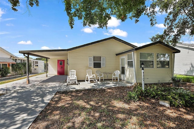 view of front of house with a carport, concrete driveway, and a patio area