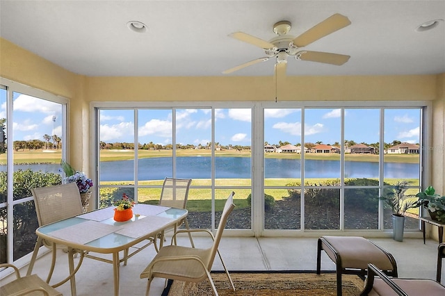 sunroom / solarium with a water view and ceiling fan