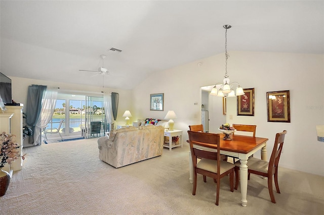 dining area featuring light carpet, visible vents, ceiling fan with notable chandelier, and lofted ceiling