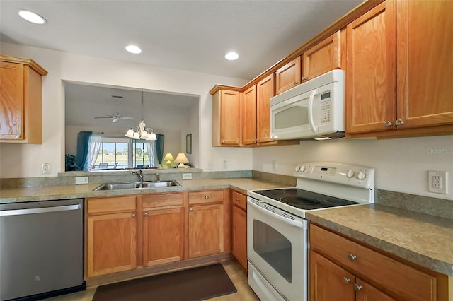 kitchen featuring white appliances, recessed lighting, brown cabinets, and a sink