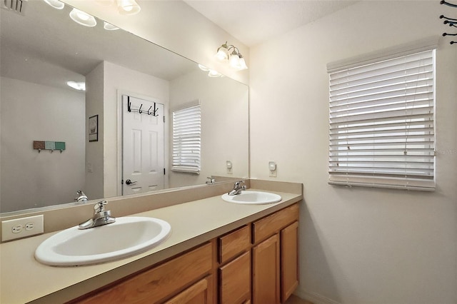 full bath featuring double vanity, visible vents, and a sink