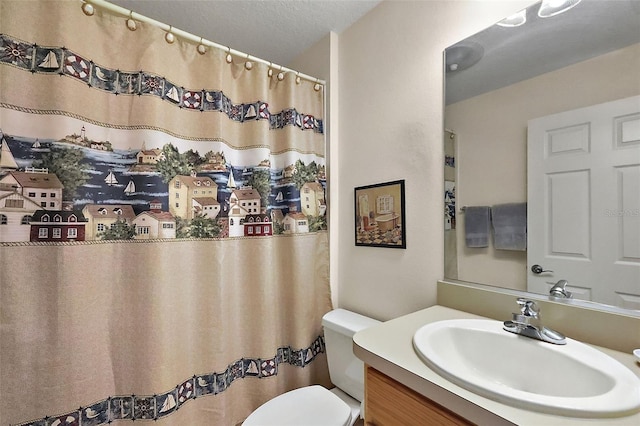 full bath with vanity, toilet, and a textured ceiling