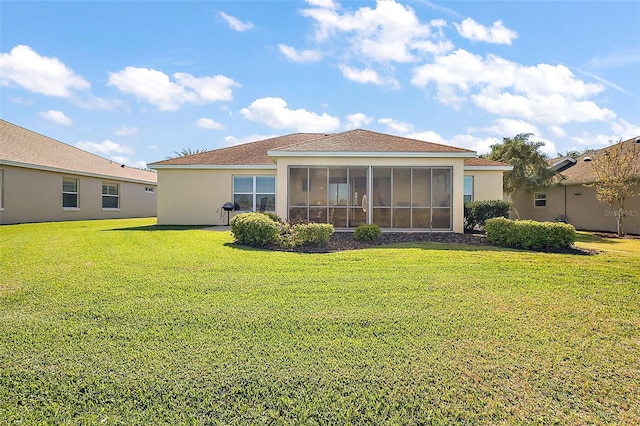 back of house featuring stucco siding, a lawn, and a sunroom