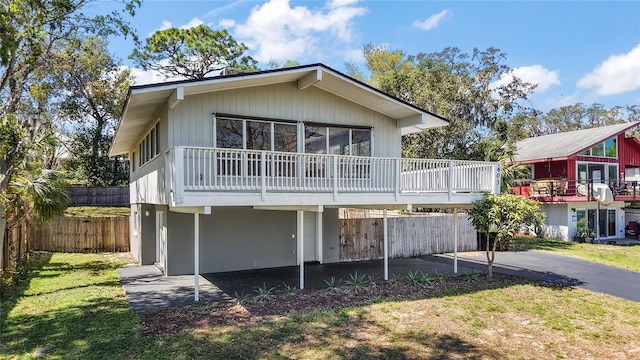 back of house featuring a patio area, a lawn, and fence