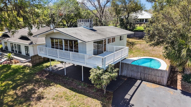 back of property featuring a lawn and a fenced in pool