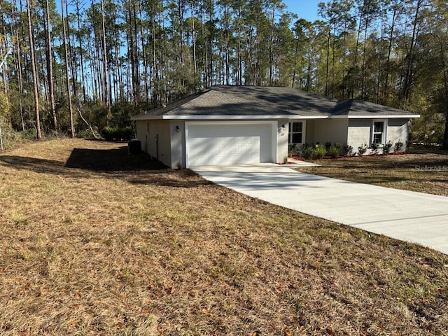 view of front of home with concrete driveway, a front lawn, a garage, and stucco siding