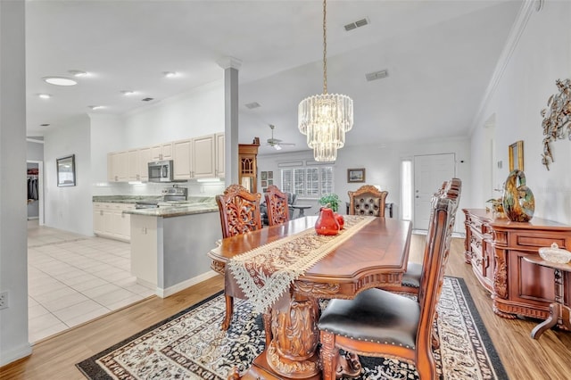 dining room featuring crown molding, ceiling fan with notable chandelier, visible vents, and light wood finished floors