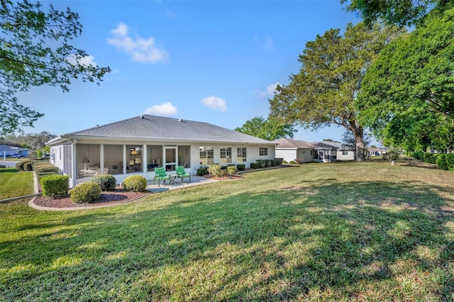 back of house with a sunroom, a lawn, and a patio area