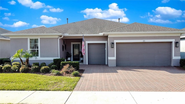 ranch-style house featuring stucco siding, decorative driveway, a garage, and a shingled roof