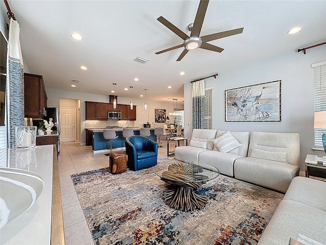 living area with light tile patterned flooring, visible vents, and recessed lighting