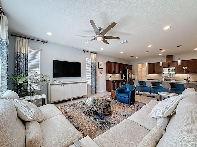 living area featuring light tile patterned flooring, recessed lighting, and a textured ceiling