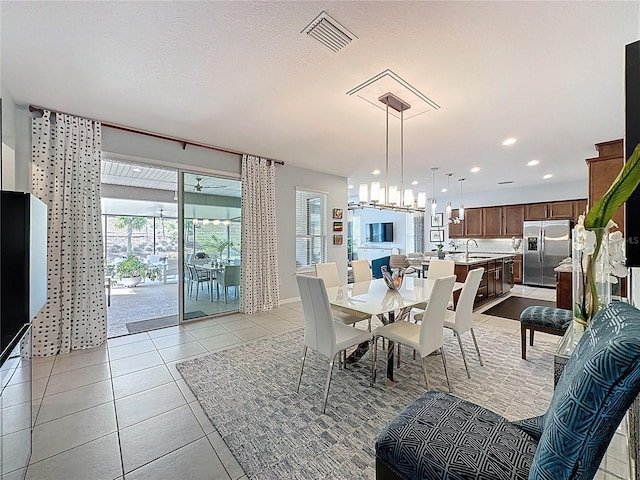 dining space with visible vents, a notable chandelier, a textured ceiling, recessed lighting, and light tile patterned flooring