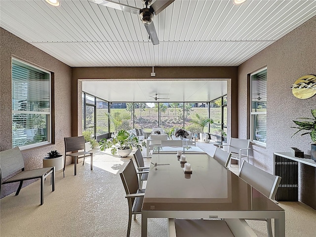 sunroom / solarium featuring a healthy amount of sunlight and a ceiling fan