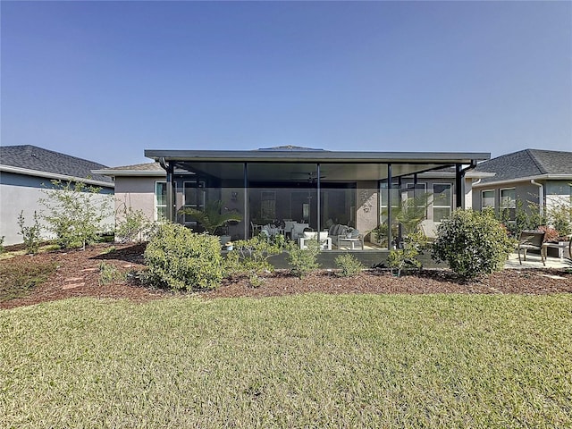 back of house featuring a lawn and a sunroom