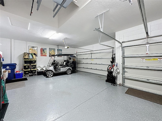 garage with a garage door opener and concrete block wall