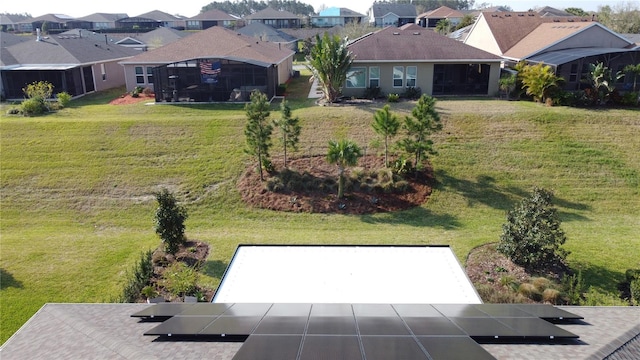 view of yard featuring a residential view, driveway, and a sunroom