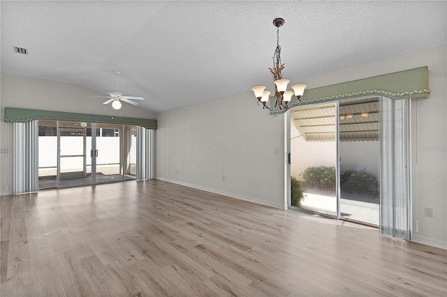 1135 Santa Cruz Dr, The Villages, FL 32162 - empty room featuring wood finished floors, visible vents, vaulted ceiling, a textured ceiling, and ceiling fan with notable chandelier
