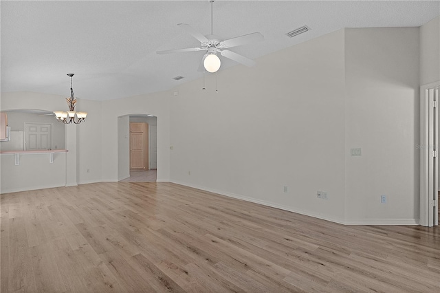 1135 Santa Cruz Dr, The Villages, FL 32162 - unfurnished living room featuring visible vents, arched walkways, light wood-style flooring, and ceiling fan with notable chandelier