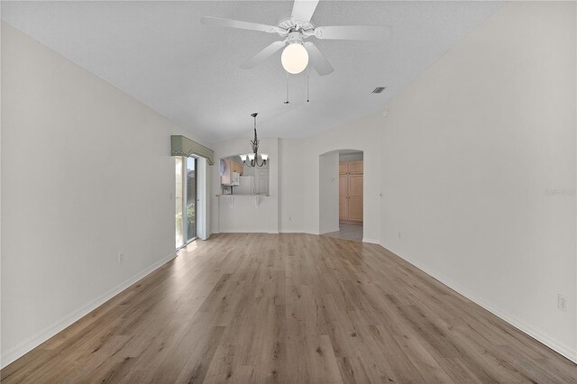 1135 Santa Cruz Dr, The Villages, FL 32162 - unfurnished living room with light wood-type flooring, ceiling fan with notable chandelier, baseboards, arched walkways, and lofted ceiling