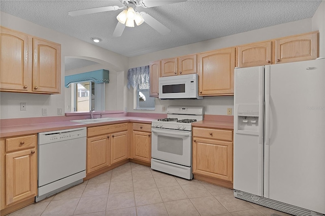 1135 Santa Cruz Dr, The Villages, FL 32162 - kitchen with white appliances, light tile patterned floors, light brown cabinets, and a sink