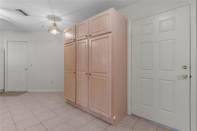 1135 Santa Cruz Dr, The Villages, FL 32162 - interior space featuring light tile patterned flooring, visible vents, a textured ceiling, and baseboards