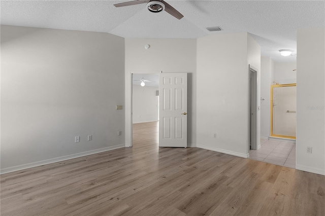 1135 Santa Cruz Dr, The Villages, FL 32162 - spare room with a textured ceiling, lofted ceiling, wood finished floors, and ceiling fan