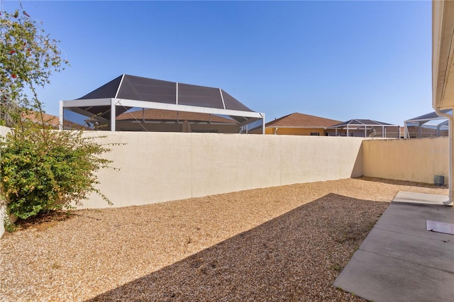 1135 Santa Cruz Dr, The Villages, FL 32162 - view of yard featuring glass enclosure and a fenced backyard