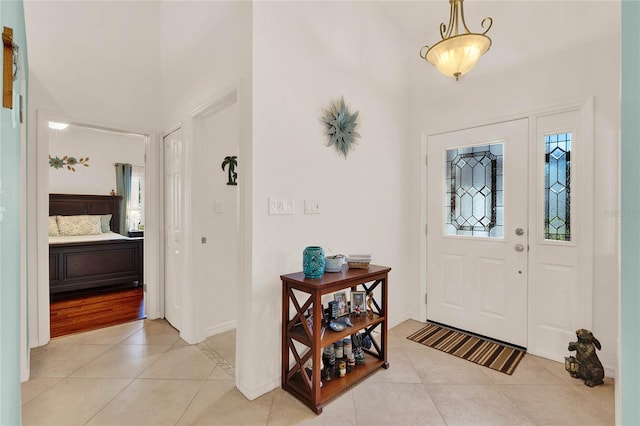 foyer entrance with light tile patterned floors and baseboards