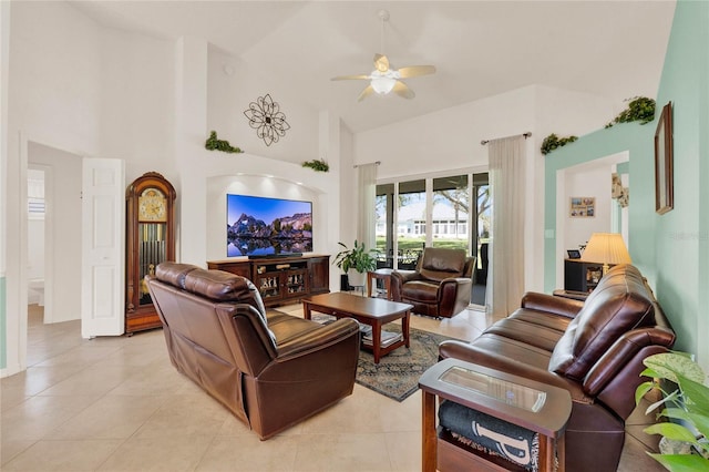 living room with light tile patterned flooring, a high ceiling, and a ceiling fan