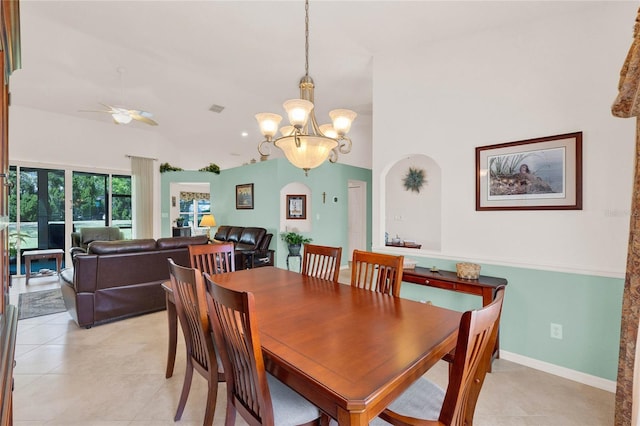 dining room with visible vents, baseboards, vaulted ceiling, light tile patterned floors, and ceiling fan with notable chandelier