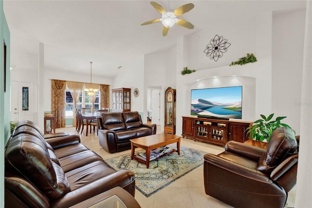 living room with light tile patterned floors, high vaulted ceiling, and ceiling fan with notable chandelier