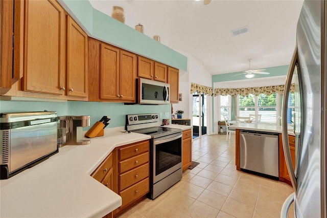 kitchen with light tile patterned floors, brown cabinetry, visible vents, light countertops, and appliances with stainless steel finishes