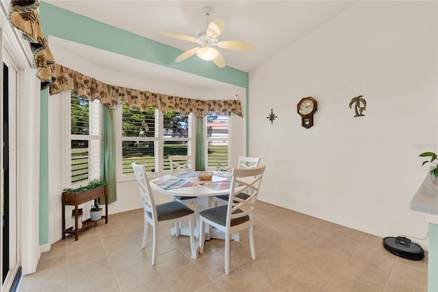 dining space with light tile patterned floors, baseboards, lofted ceiling, and ceiling fan