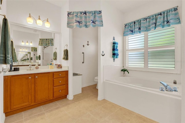 bathroom with a garden tub, toilet, vanity, and tile patterned flooring