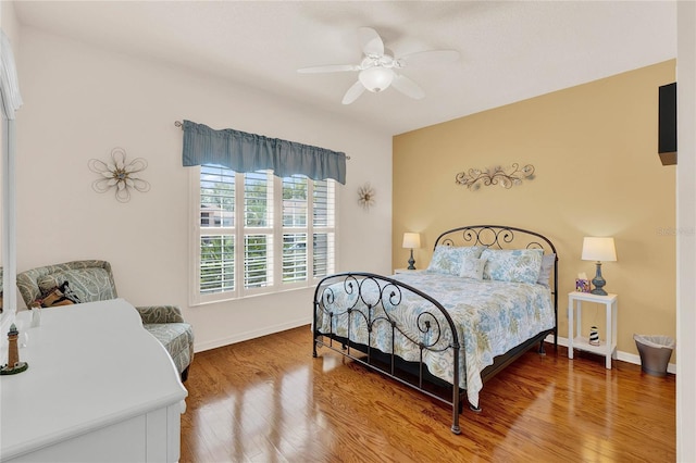 bedroom featuring ceiling fan, baseboards, and wood finished floors