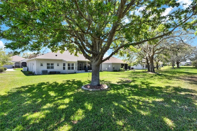 view of yard with a sunroom and central AC