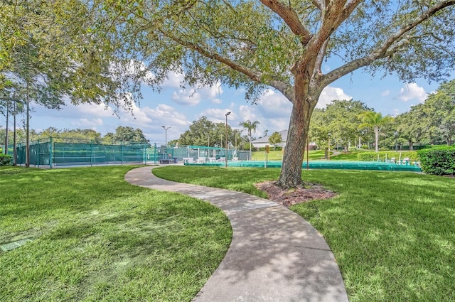 view of property's community with a yard and fence