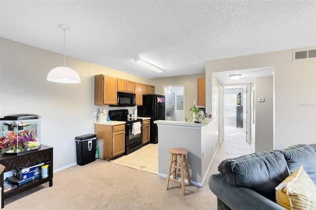 kitchen featuring visible vents, black appliances, open floor plan, and light countertops