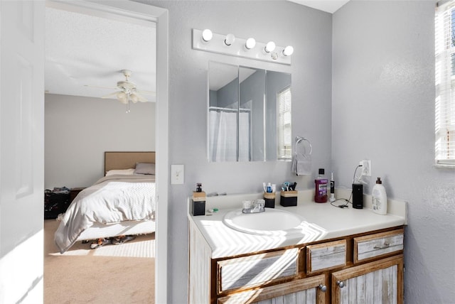 bathroom featuring vanity, a shower with shower curtain, a ceiling fan, ensuite bath, and a textured wall