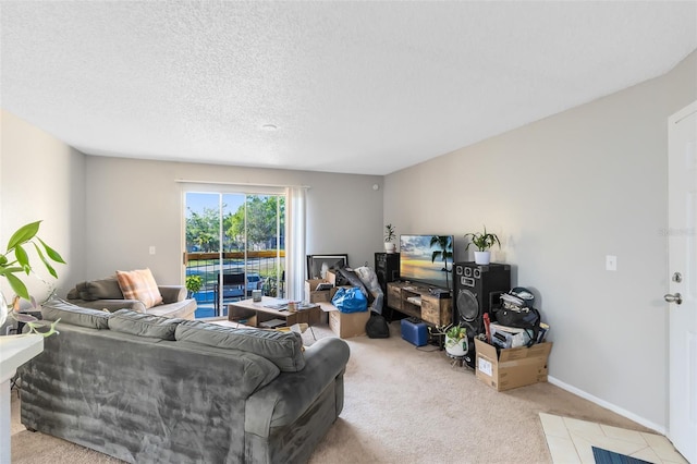 living room featuring baseboards, a textured ceiling, and carpet flooring