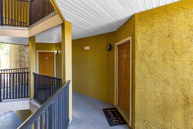 property entrance featuring stucco siding and a balcony