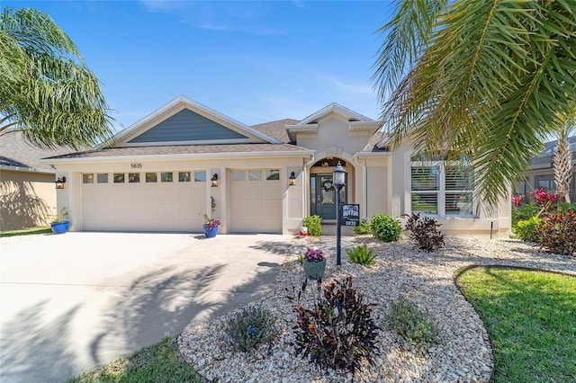 view of front of property with stucco siding, driveway, roof with shingles, and an attached garage