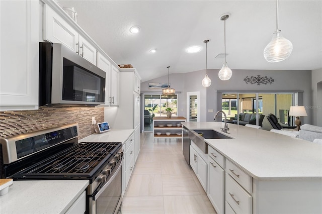 kitchen with backsplash, a center island with sink, appliances with stainless steel finishes, white cabinetry, and a sink